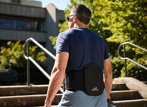 A man in a back brace ascends stairs