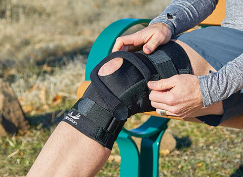 A close-up of a knee brace on a person’s leg