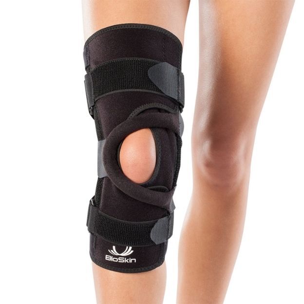 BioSkin knee brace on a model’s leg, open-patella design with support straps for kneecap tracking and compression.