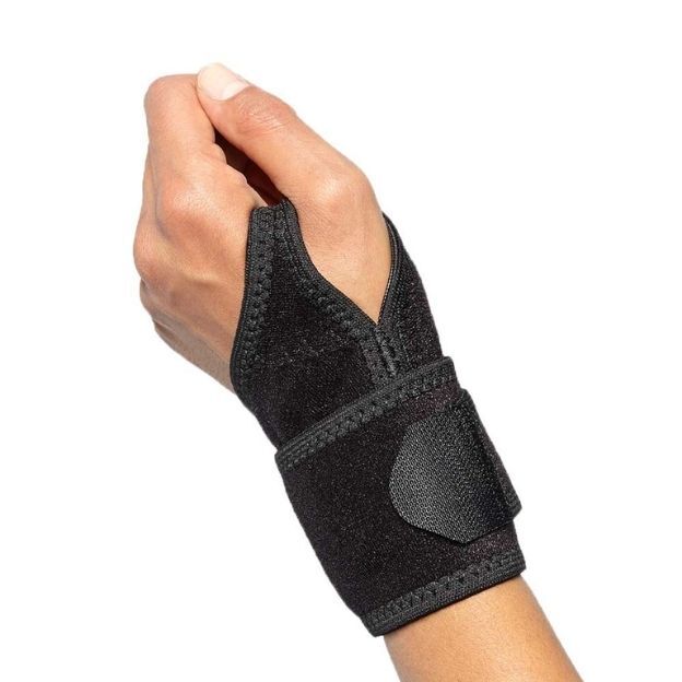 Hand wearing a black Boomerang wrist wrap with adjustable wrap strap on a plain white background.
